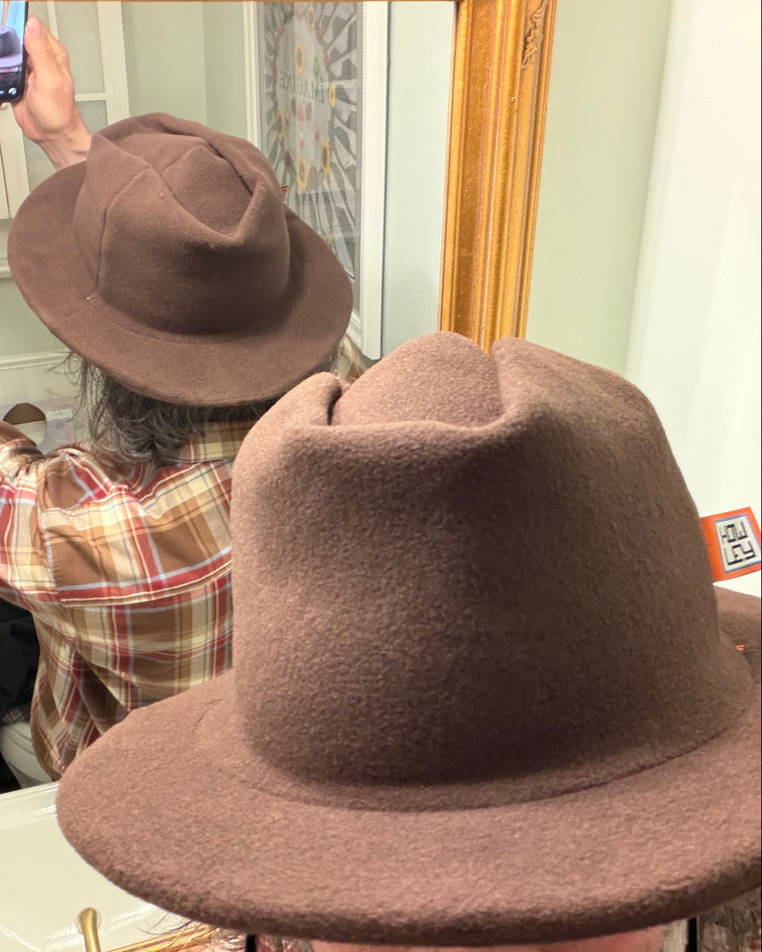 A selfie of a Howley brimmed hat shown from the front and back.