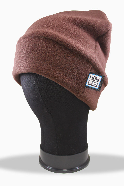 Brown beanie on a mannequin head with a visible brand label against a white background