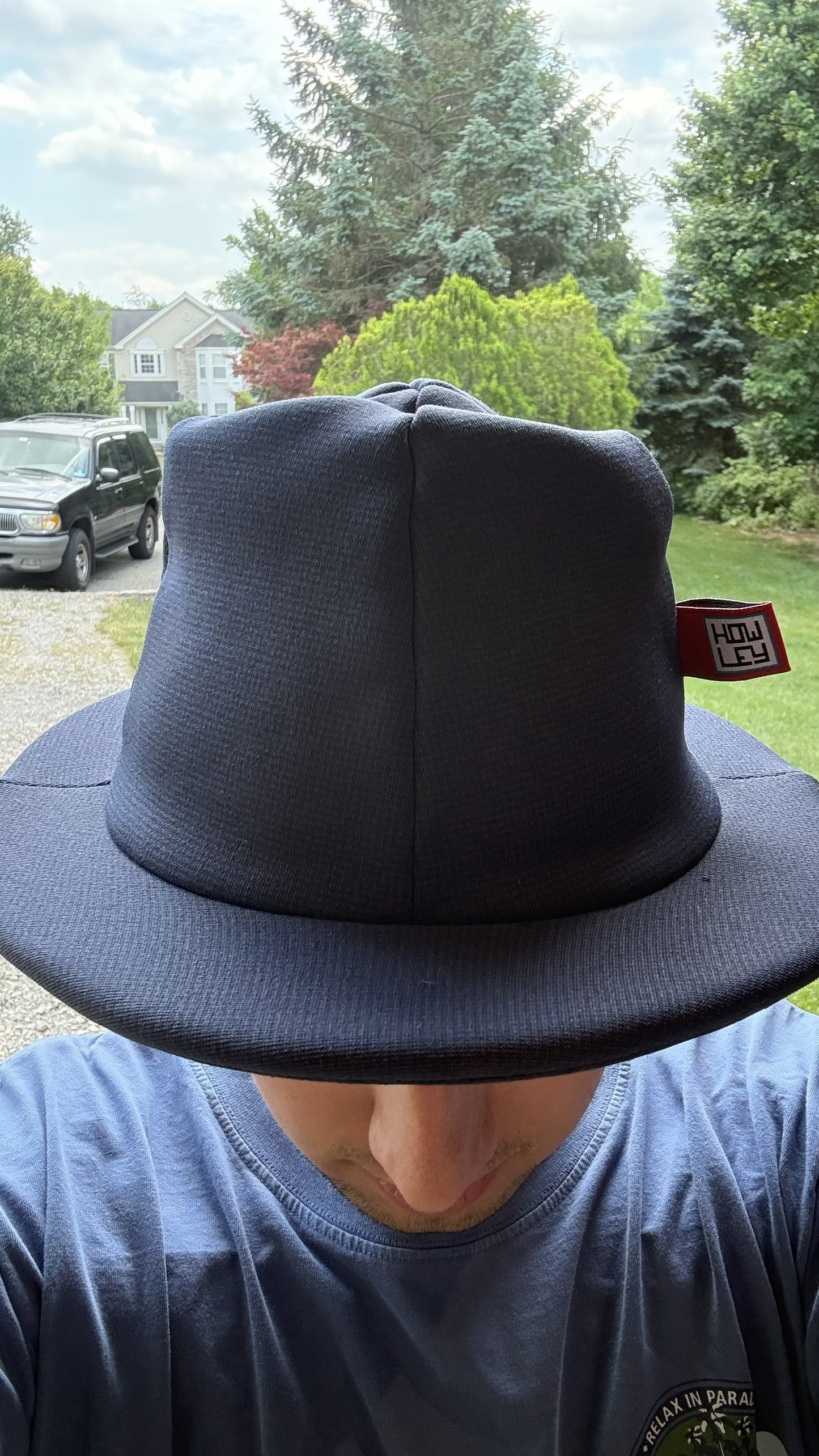 Person wearing a black hat with a visible brand logo outdoors.