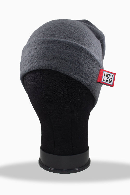 Gray beanie on a black mannequin head with a visible brand label against a white background
