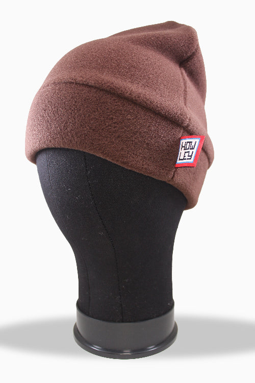 Brown beanie on a mannequin head with a visible brand logo against a white background