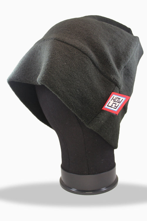 Dark gray beanie with a red label on a black mannequin head against a white background